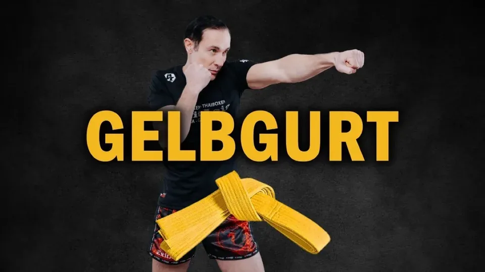 Cover Gelbgurt: Trainer mit gestrecktem Schlag hinter einem gelben Gürtel