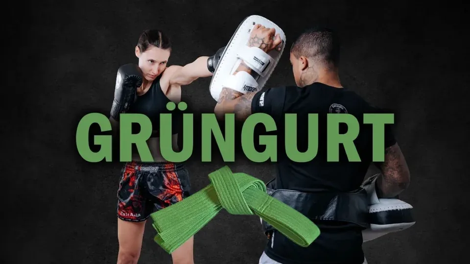 Cover Grüngurt: Trainerin schlägt auf die Pratze eines Trainers, grüner Gürtel im Vordergrund