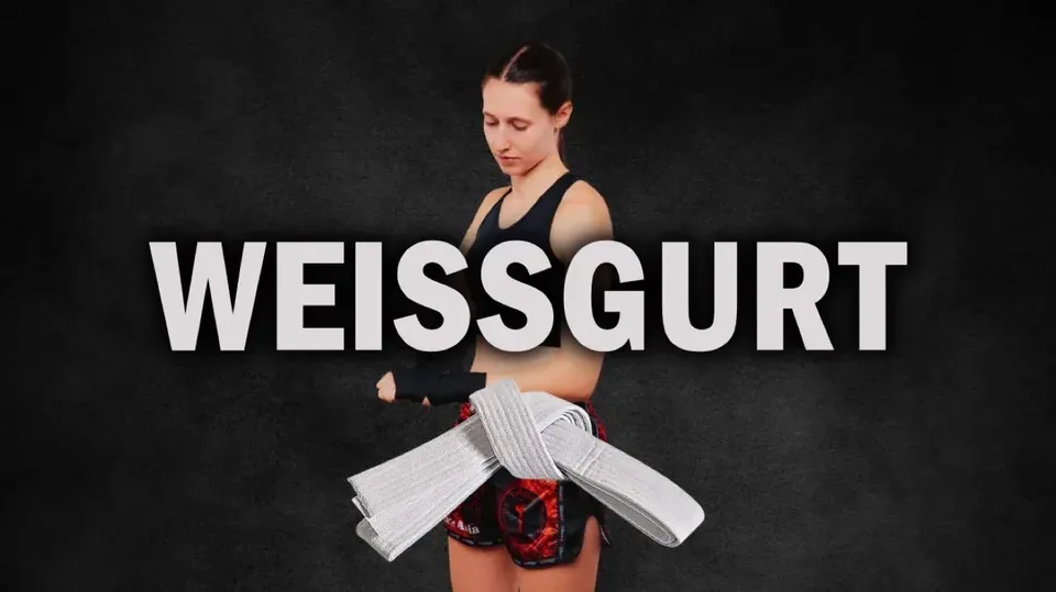 Cover Weißgurt: Trainerin hinter einem weißen Gürtel auf dunklem Grund