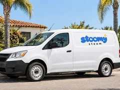 White van with the Stoomy Steam logo on its side in front of a house with palm trees in Los Angeles — mockup